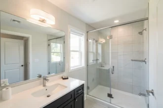 Salle de bain claire avec plafonnier et douche à l'italienne